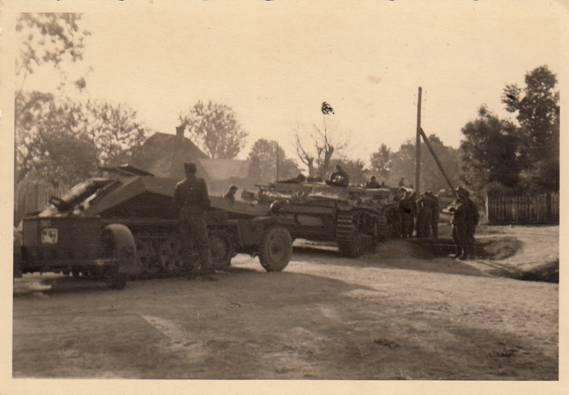 The 1. / Stug. Abt. 243 in Oleszice - 22 Jun41; in the foreground a Sd Kfz 252 (le.gep.Mun.Trsp.Kw.)....................