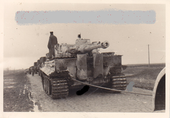 A whitewashed Pz Kw VI Tiger Ausf. E, with the turret rotated 180 degrees and towing a truck (apparently) .................