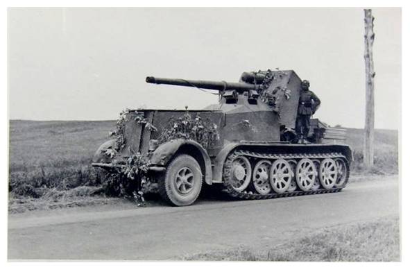 An 8.8 cm Flak 18 (Sfl) auf Zukraftwagen 12t (Sd.Kfz 8) during a stop in its march ....................................................