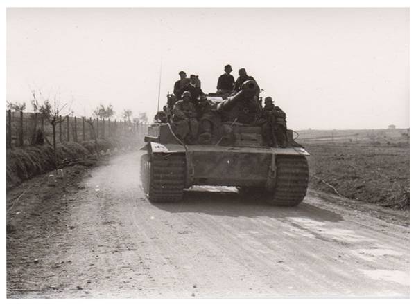 One Pz Kw VI Tiger Ausf. E on the move to the front with a group of grenadiers on it...........................