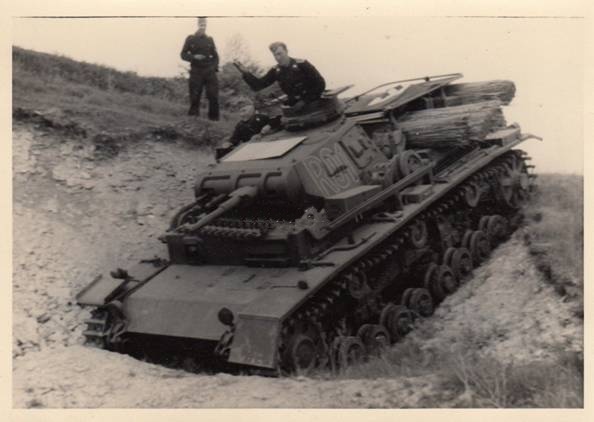 PanzerBefehlswagen III - Ausf.D1 (assigned to the commander of the regiment R01) trying to overcome a terrain obstacle; on the engine cover, two fascines for soft terrain and extended on it the flag for identification from the air as a friend ....................................................