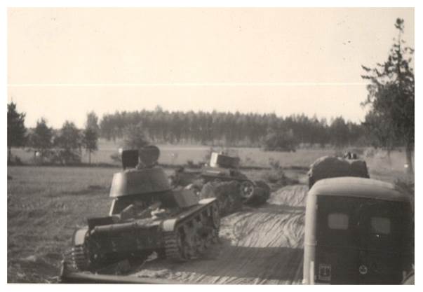A German column overtakes two Soviet T-26 light tanks disabled in previous combats..............