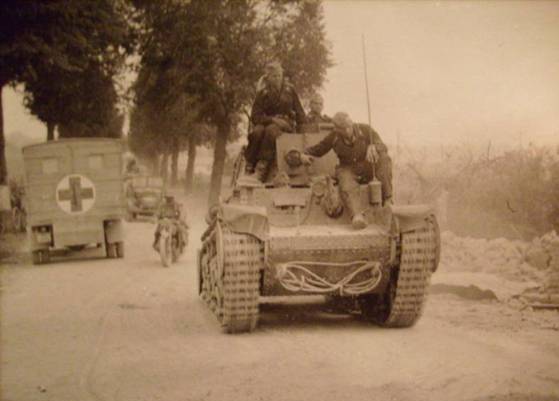 A German Column rolling ahead over a dusty road. In the lead a Pz Kw 35 (t)?.