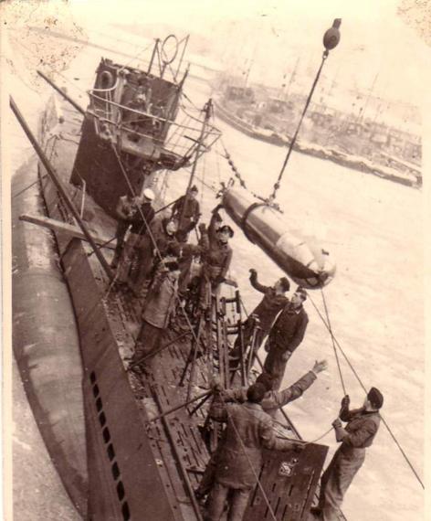 A U Boat (Type VII) taking a drill torpedo aboard.................................