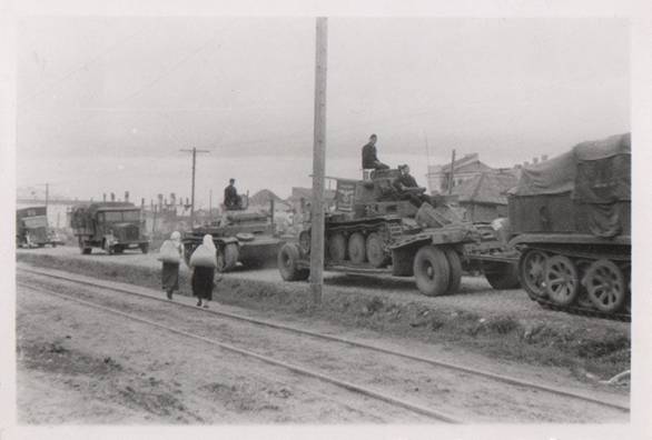 A German column on the move, in it a Sd. Ah. 115 carrying a Pz Kw 38 (t) and towed by a Zugkraftwagen; behind a Pz Kw II ......................