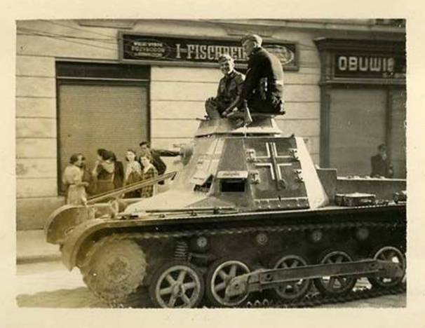 Close view of a Sd Kfz 265 Panzerbefehlswagen I on a chassis Ausf. B, carrying the different cross; behind posters in German and Polish (Obuwie - Footwear).....................