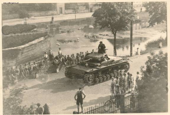 A Pz Kw III Ausf. D (apparently) rolling under the watchful eyes of the local population ......................