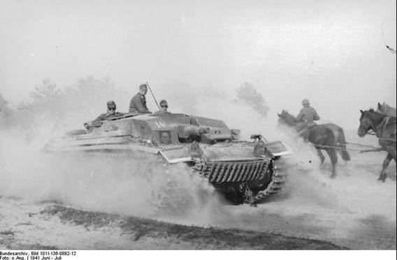 The Stug III Ausf. B No. 14 on the move, in the opposite direction one horse-drawn column.....................................